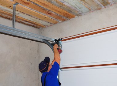 Contractor Installing Garage Door Post Rail and Spring Installation and Garage Ceiling.