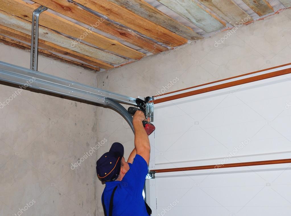 Contractor Installing Garage Door Post Rail And Spring