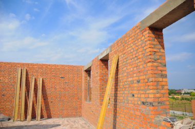 Yapım aşamasında çatı olmadan bitmemiş kırmızı tuğlalı ev duvarlarının iç. Attic Windows delik çerçeve İnşaat açık havada bakış