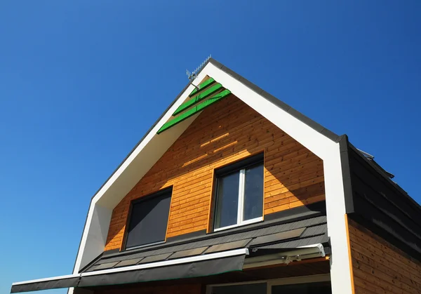 Modern ev dış tasarımı. Yeni bina ev enerji verimliliği çözüm kavramı açık. Güneş enerjisi, güneş panelleri, bitüm döşenmiş çatı yüklü. — Stok fotoğraf