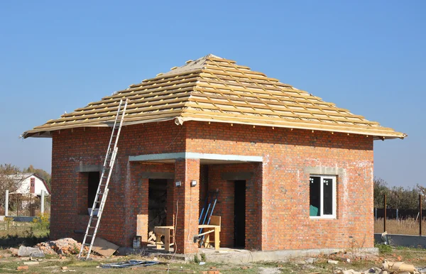 Revestimientos de membrana de techo Construcción de madera Estructura del hogar con balseros de techo y escalera de metal Exterior contra un cielo azul. Construcción de techos Exterior con casa de ladrillo rojo Fachada de pared . — Foto de Stock