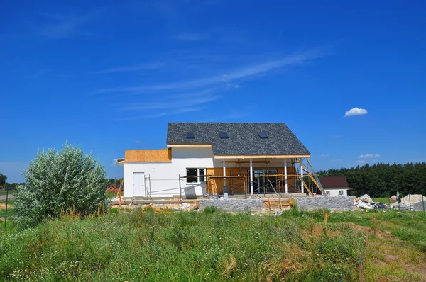 Beautiful New Cozy House Building Construction Exterior. Cozy house with Dormers, Skylights, Ventilation, Gutter, Drainage, Plastering and Using Color.  Outdoor.