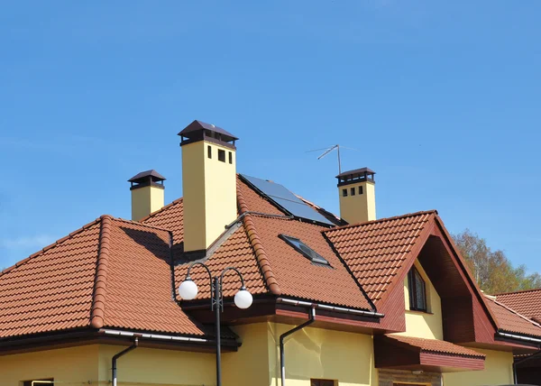 Closeup της το ηλιακό συσσωρευτή στη στέγη κόκκινο σπίτι πλακάκια — Φωτογραφία Αρχείου
