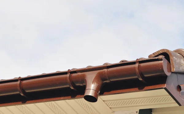 Neue Regenrinnen-Abflussrohr-Fallrohrinstallation an der unfertigen Hausfassade Außenwand — Stockfoto