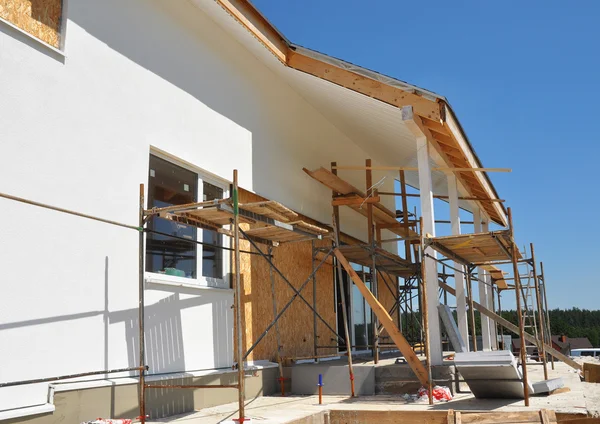 Construction ou réparation de la maison rurale avec puits de lumière, avant-toit, fenêtres, façade de fixation, isolation, plâtrage et peinture Maison Façade Mur — Photo