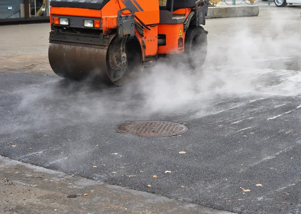 Riparazione stradale, compattatore posa asfalto. Riparazione pavimentazione e posa di nuovo metodo di patch di asfalto all'aperto . — Foto Stock