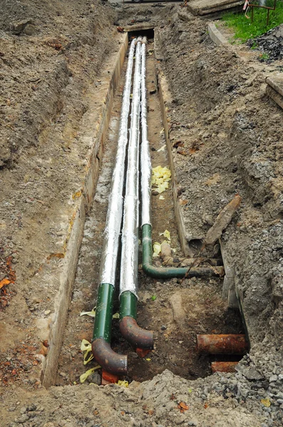 Breakthrough sewerage system in the city street. Pipes for water in an earthen trench. Repair, insulation and replacement of sewer. — Stock Photo, Image