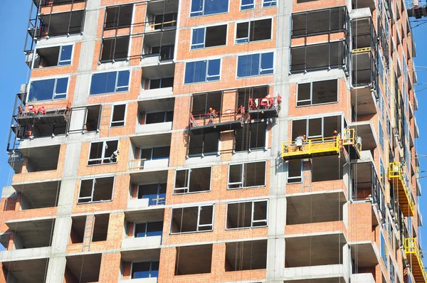 Inspeccionando el sitio de construcción grande. Trabajadores construyendo nueva casa, instalar ventanas, Insulación mural, Balkony. Construcción de edificios industriales . — Foto de Stock