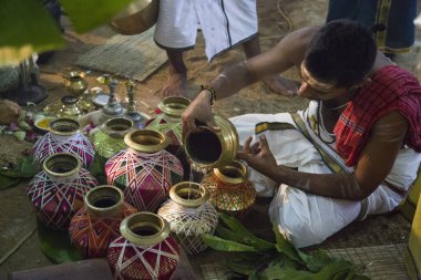 Geleneksel otlar ve suyla yagasalai poojai hazırlığı bir Hindu rahip tarafından tapınağın içine bakır ve pirinç kaplar yerleştirildi..
