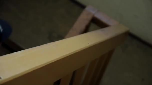 Poręcz drewniana ostrości w. Człowiek w kurtka, plecak w górę schodów wewnątrz budynku — Wideo stockowe
