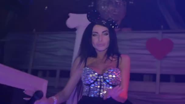 MC meisje in muis oren, kristallen Romper uitvoeren in nachtclub. Kijken in de camera — Stockvideo