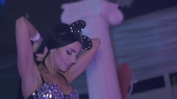MC дівчина в вухах миші, боді-костюм, роблять невеликі кроки на високих підборах в нічному клубі . — стокове відео