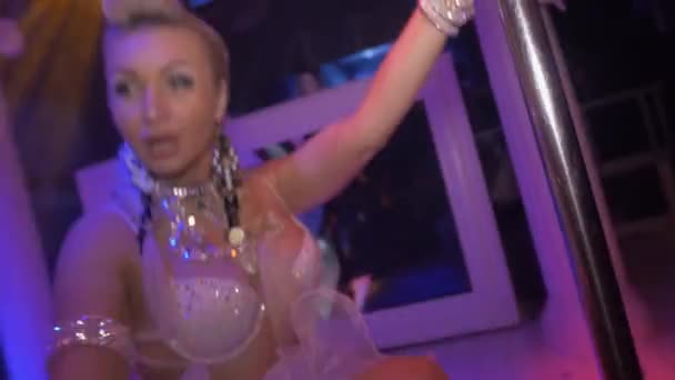 Go go girl in white volume skirt, beige bra at pole in nightclub. Erotic touch — Stock Video