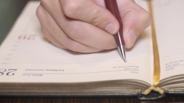 Δικαίωμα επανδρώνει το χέρι λέξη εγγραφής επιχειρήσεων στο σημειωματάριο εγγράφου από ένα στυλό. Κοντινό πλάνο — Αρχείο Βίντεο