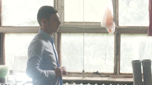 Ember begombol kék vasalt ing nézz tükörbe. Ablakot a háttérben. Ruhák — Stock videók