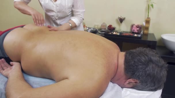Професійний масажист повертається до дорослого товстого чоловіка. Середній постріл . — стокове відео