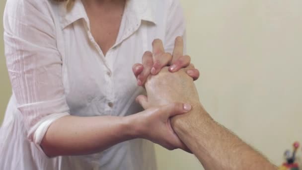 Närbild av massör händer göra massage av hand handled till vuxen man. Healing — Stockvideo