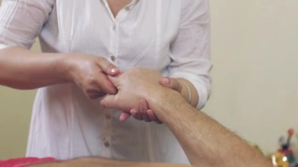 El primer plano de las manos masajistas hacen el masaje de los dedos de la mano al hombre adulto. Asistencia sanitaria — Vídeo de stock