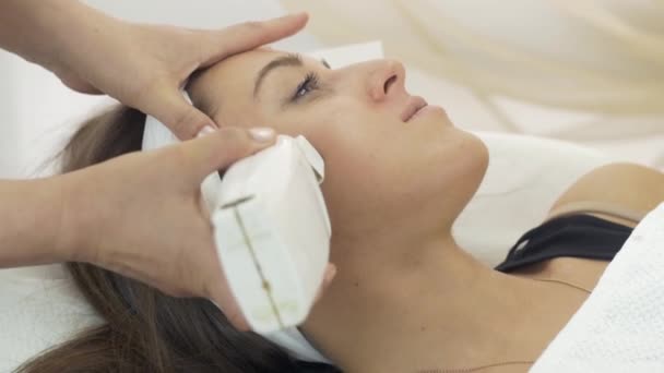 Close up of cosmetologist hands put wax on cheeks of girl in beauty saloon. — Stock Video