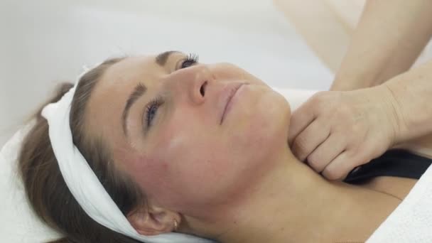 Gros plan des mains du cosmétologue faire épilation du cou de la fille dans le salon de beauté . — Video