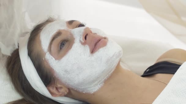 Primer plano cosmetólogo manos cubrir chica cara con máscara por gasa en salón de belleza — Vídeo de stock