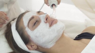 Darsonvalization kız yüz kil maskesi salon kapatın. Kozmetik prosedür.