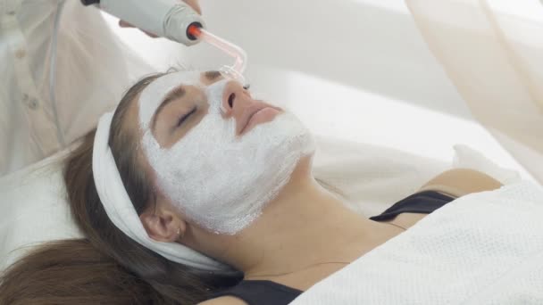 Närbild av darsonvalization ansikte av flicka med mask i salongen. Kosmetiska förfarande — Stockvideo