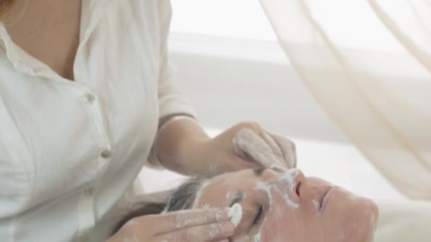 Close up cosmetologist hands, face wipe off mask out girl face in beauty saloon — Stock Video