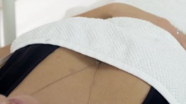 Kız yalan Güzellik Salonu kozmetik prosedürler üzerinde beyaz battaniye altında. Yakın çekim.