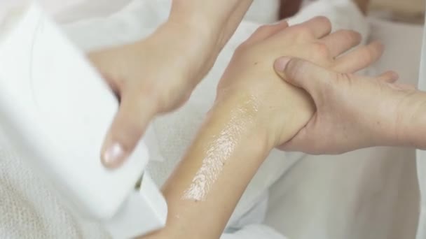 Nahaufnahme von Kosmetikern Hände legen Wachs auf Handgelenk von Mädchen Hand in Schönheitssalon — Stockvideo