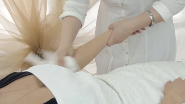 Il cosmetologo professionista asciuga la mano sinistra della ragazza nel salone di bellezza. Colpo medio — Video Stock