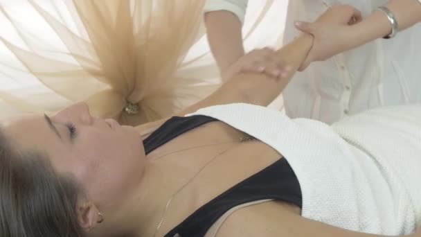 As mãos de cosmetologist fazem a massagem da mão de menina no salão de beleza. Tiro médio — Vídeo de Stock