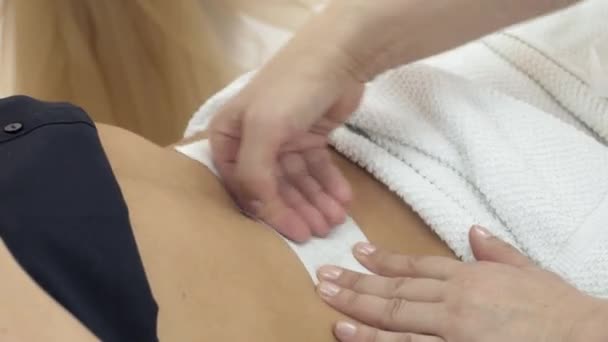 Close-up de mãos cosmetologist encerando estômago de menina no salão de beleza — Vídeo de Stock