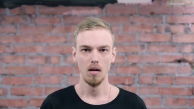 Genç sakallı adam siyah kazak korkusu tasvir, korku kamera. Seçmeler.