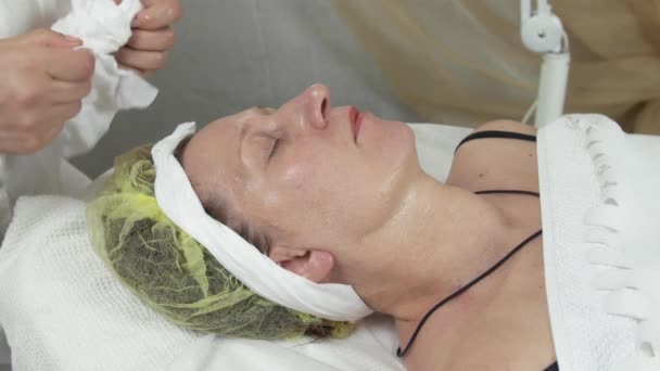 Cosmetologue essuyer le visage de la femme dans le saloon en nettoyant la serviette. Soins anti-âge — Video