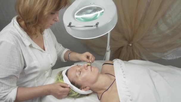 Cosmetologo che fa la faccia di galvanoterapia di donna adulta in salone di bellezza . — Video Stock