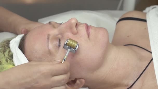 कॉस्मेटोलॉजिस्ट सौंदर्य सलूनमध्ये धातू रोलरद्वारे स्त्रीचा गॅल्वनाइथेरपी चेहरा बनवतात — स्टॉक व्हिडिओ