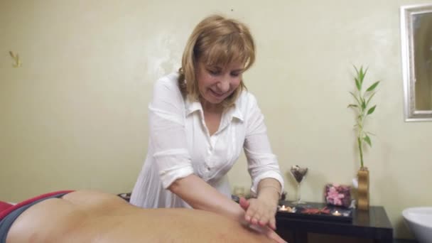 Masseuse specialist massage linker kant van terug naar volwassen Fat Man. Medium shot. — Stockvideo