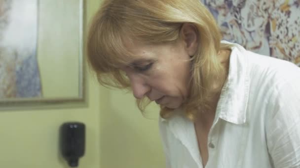 Косметолог вытирает лицо женщины в салоне хлопка за маской из водорослей — стоковое видео