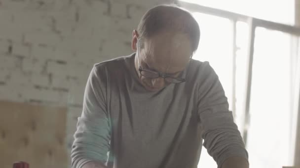 Aged charpentier polissent la planche en bois par la machine de ponceuse de ceinture. Fabricant 