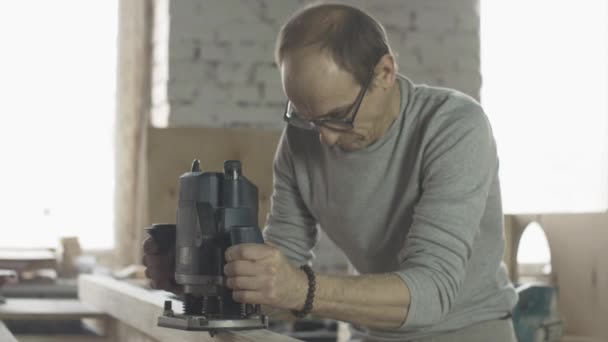 Houten plank leeftijd timmerman aandachtig behandelen door duikrouter. Fabrikant — Stockvideo