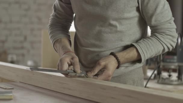 Cerrajero profesional hacer marcas en tablero de madera por regla especial. Muebles — Vídeo de stock