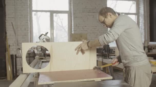 Carpintero profesional conecta dos tableros de madera. Martillo. Proceso de montaje — Vídeo de stock