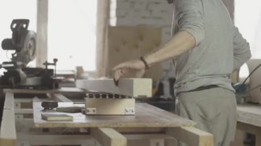 Woodworker put edge of long wooden board under circular saw. Furniture.