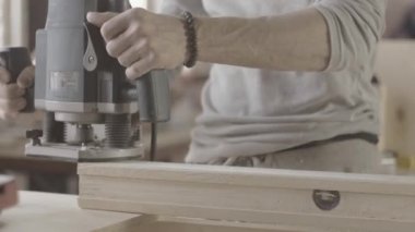 Woodworker treats edge prepared wooden board by polishing machine. Manufacturer