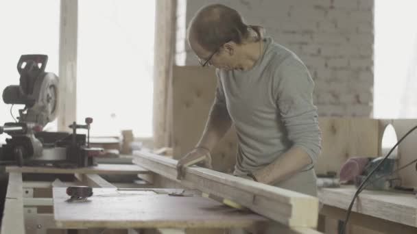 Professionelle Holzbearbeiter polieren lange Holzbretter mit einem speziellen Schwamm. Möbel. — Stockvideo