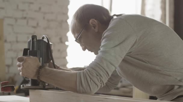 Woodworker tratta il bordo del bordo di legno dal router del tuffo. Tagliagli il dito. — Video Stock