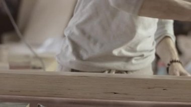 Woodworker dye long wooden board by varnish. Roller. Manufacturer. Treatment