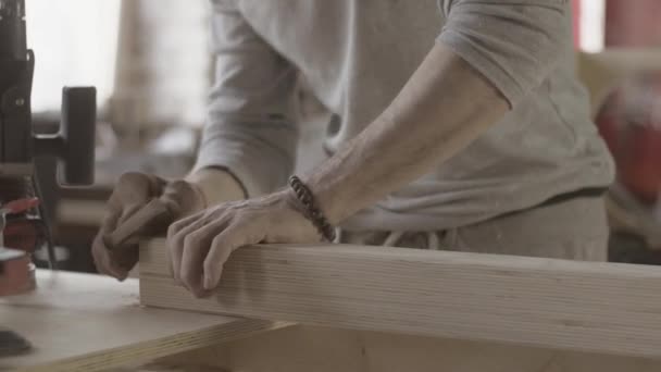 Woodworker polish edge of long wooden board by special sponge. Manufacturer — ストック動画