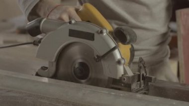 Marangoz dikkatli metal balk düz çizgi üzerinde ahşap tahta kesti. Dairesel testere